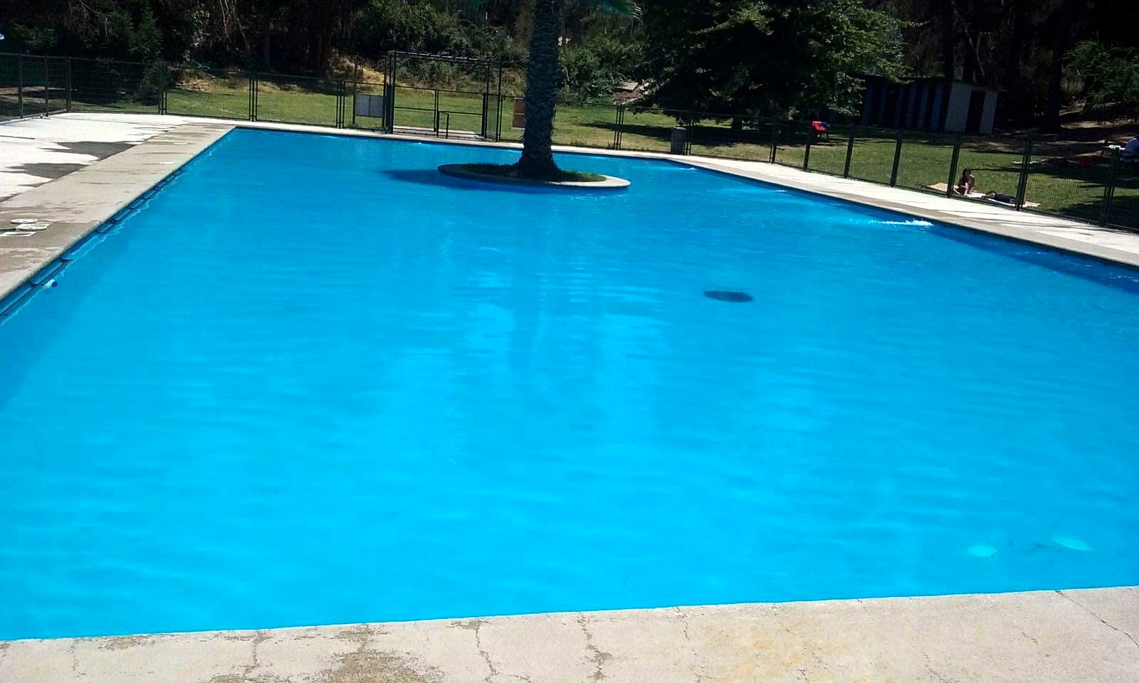 Piscina de borde infinito junto a casa de piedra